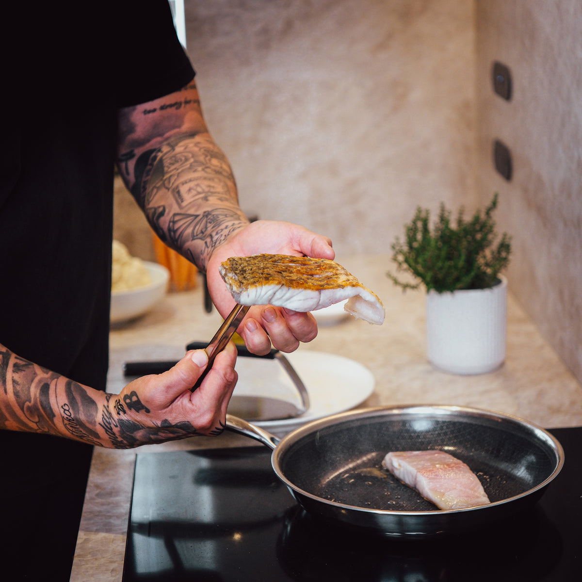 Ruokapihdit nostavat kalaa paistinpannusta